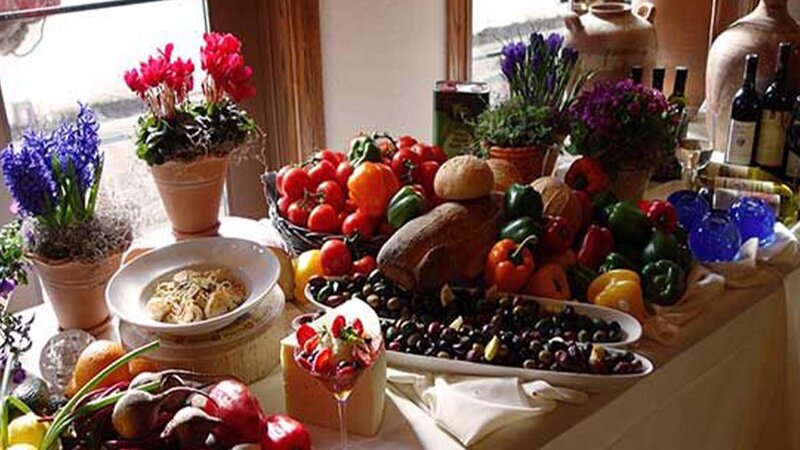 Buffet tabled displaying an array of olives, vegetables and wines